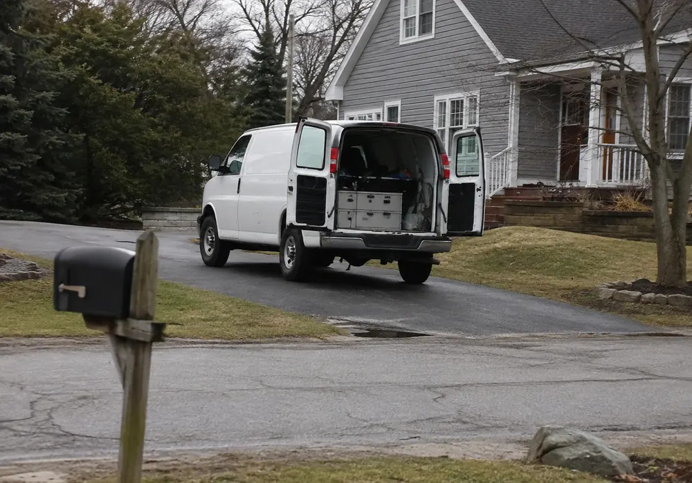 HVAC service van with rear doors open on a residential street